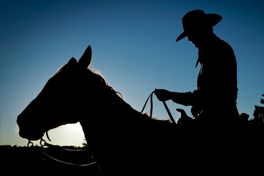 Cowboy Silhouette on Horse Against Sky Western Concept Image