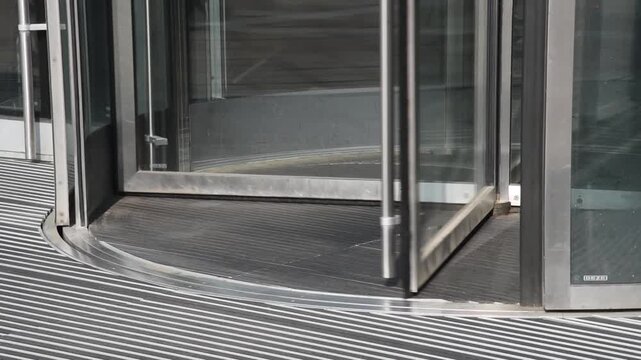business center in big city, central entrance with revolving door, people come in and go out, modern architecture, urban background