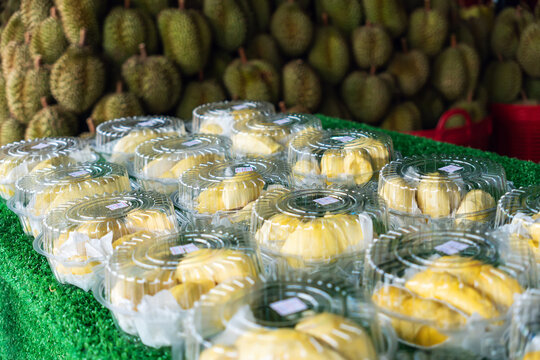 Durian fruit that has been peeled and placed in a foam tray and wrapped in clear plastic are placed on the table waiting for customers to buy and eat. durian on the counter in the store.