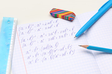 Obraz premium Copybook with maths formulas and stationery isolated on white background