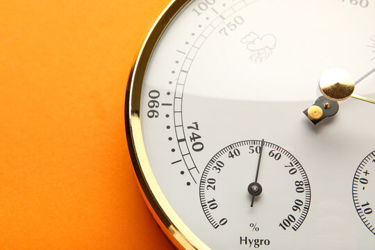 Aneroid barometer on orange background