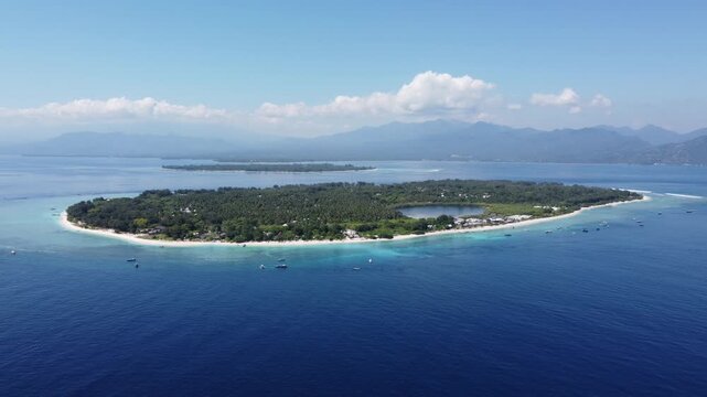 Cinematic elevated aerial drone hovering above Gili Trawangan with neighboring islands and Lombok in view, Indonesia.