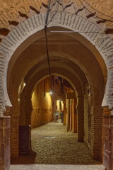 Obraz premium Night horseshoe-arched passage under traditional houses, lit by the street lamps of a cobbled alley in the medina neighborhood. Marrakesh-Morocco-253