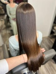 Naklejka premium Hair care concept, silky smooth straight hair after salon keratin procedure