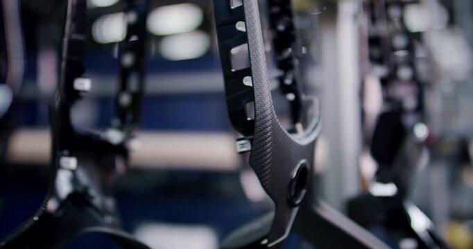 Close up of carbon fiber textured plastic automotive interior parts hanging on a production line
