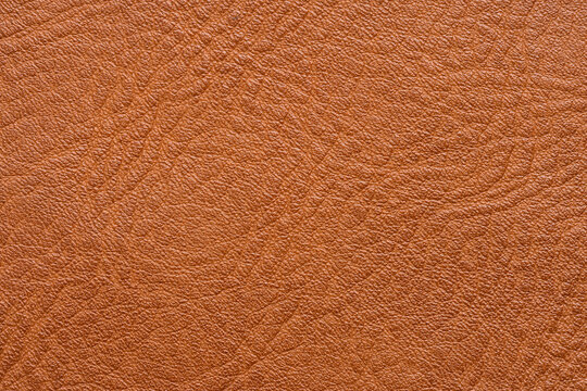 Top view of brown leather texture background with side stitching,Close-up macro of natural tan leather material, showing detailed grain pattern and sewing thread for fashion, upholstery,