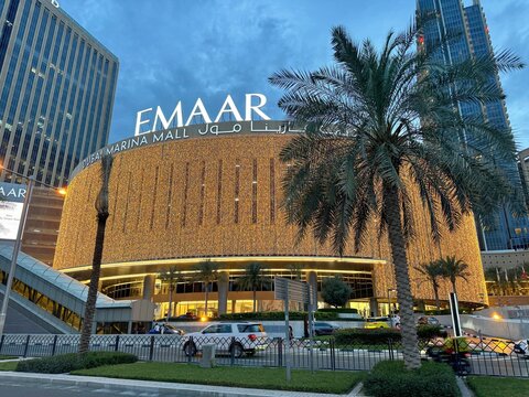 Dubai Marina Mall facade covered in gold fairy lights and Emaar branding during the blue hour, UAE, 2024