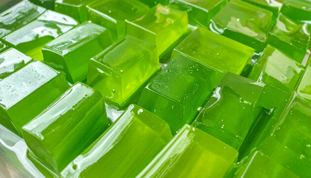 Close up of vibrant green gelatin cubes freshly prepared for dessert