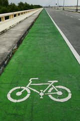 Obraz premium Urban Cycling Path Green Lane with the Bikeway Symbol on asphalt pavement. Street scene for eco transportation, commuting, or city infrastructure.