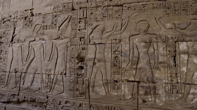 Karnak Temple in Luxor, Egypt. Close-up ancient Egyptian wall relief with pharaoh and gods figures, cartouche and hieroglyphics at Karnak Temple Luxor. Authentic history and documentary.