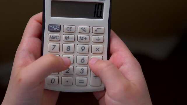 Child Hands Pressing Buttons on Handheld Calculator &mdash; Early Numeracy, STEM Learning, Mathematics Education and Childhood Learning Concept