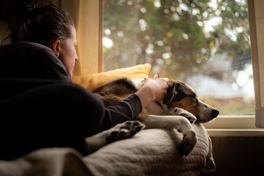 A woman relaxing on a couch with a dog