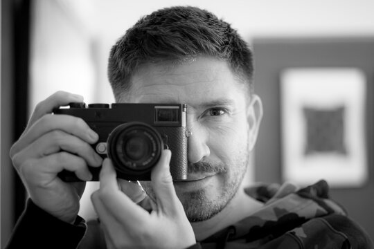 A man posing with a camera.