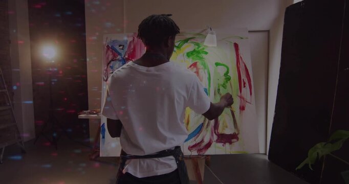Painting painter in apron seeing broad marks, applying red strokes on easel with brush in studio