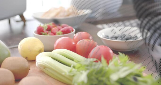 Perforated mesh sweeping frame, revealing strawberries, kiwis, striped arm passing behind for food