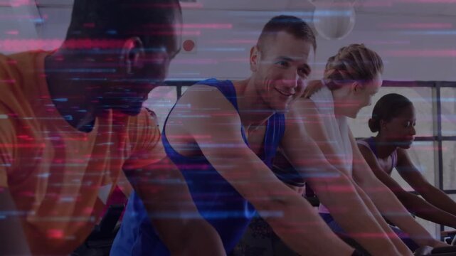 Four on spin bikes pedaling in fitness, center rider leaning initiating banter as glitch sweeping