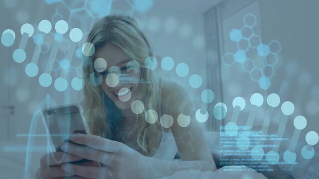 Holding phone, woman wearing white camisole laughing and reclining on bed with hologram DNA overlay