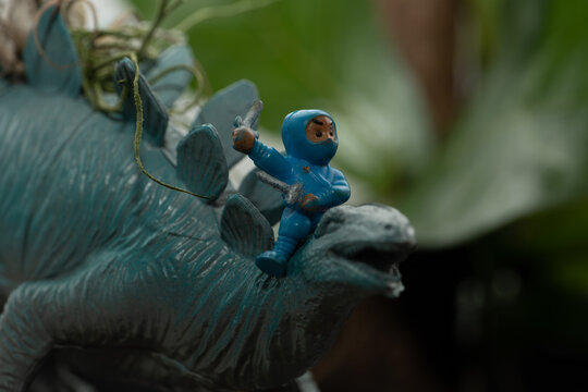 Tiny ninja figurine with a stegosaurus toy.