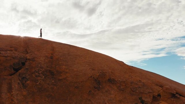 Drone shot with girl walking over the rock in Namibia in Spitzkoppe national park.