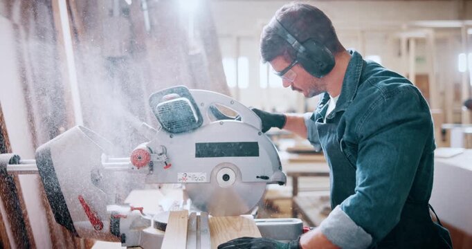 Bandsaw, carpentry and dust with man in warehouse for manufacturing or production process. Goggles, ppe and sawing machine with person in woodworking plant to resize lumber or timber for project