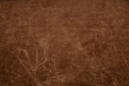 Natural scratched brown leather texture. Worn leather background surface.