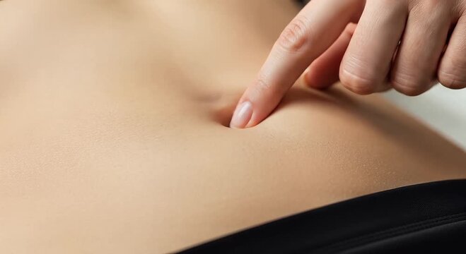 close-up finger touch on smooth abdomen skin