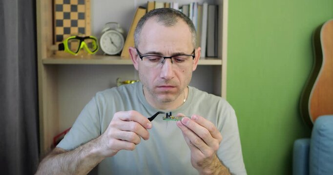 Engineer placing electronic component on circuit board during prototype development using precision tools. Concept of hardware engineering, product design, and technology development.