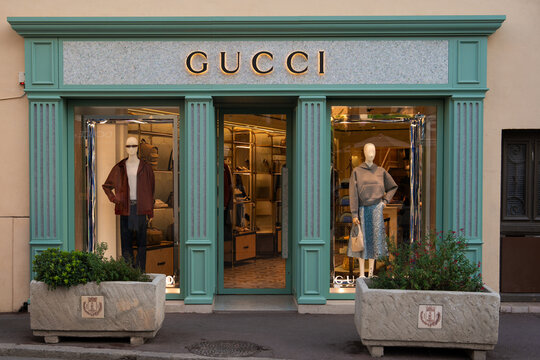 SAINT TROPEZ, FRANCE - AUGUST 28, 2024: The facade and window display of a Gucci store with mannequins in clothing. logo
