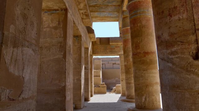 Great Hypostyle Hall at Karnak Temple, Luxor Egypt. Massive painted columns with original red hieroglyphics soaring against bright blue sky. Iconic ancient architecture.