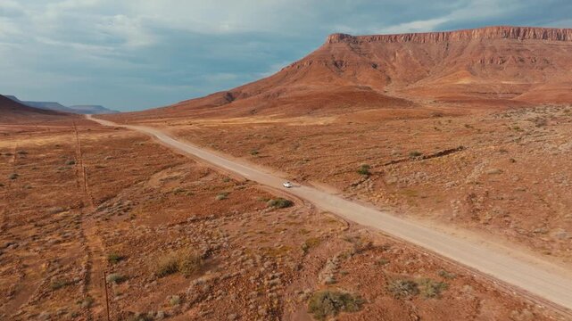 Drone shot with riding 4x4 car in Namibia desert.