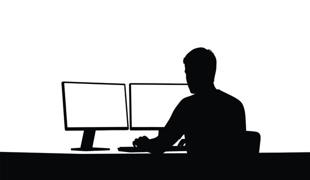 Silhouette of a person sitting in front of two computer monitors