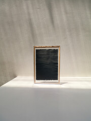 Handmade black paper in plastic frame on white table