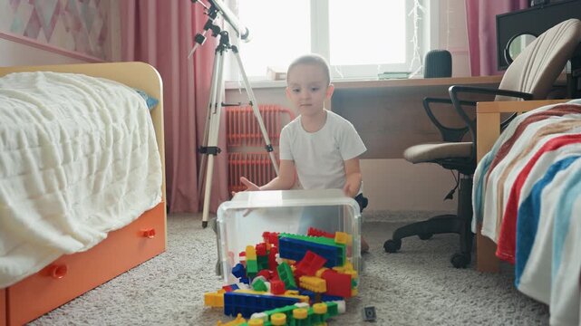 Child engaging with toys in natural light. Playful child surrounded by vibrant building blocks at home. An independent child enjoys times of creative play with colorful bricks near window