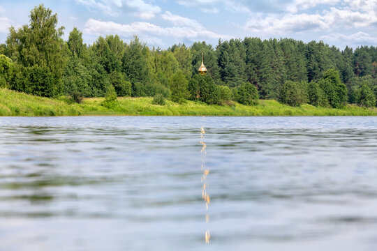 Reflection of the golden dome of the Orthodox chapel in the river water