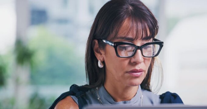 Serious, glasses and businesswoman with laptop in office, proofreading and editing story on website. Magazine editor, eyewear and mature person with tech for media publication, online and creative