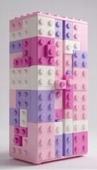 Obraz premium Una torre construida con bloques de Lego en tonos pastel de rosa y lila.