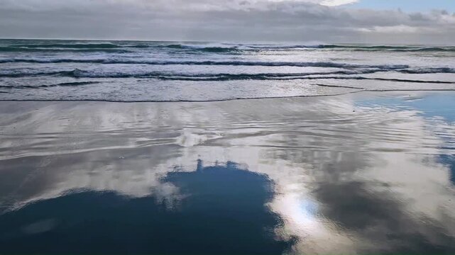 Water Ripples and Light Reflections on Shallow Shoreline. Sand blows into the Tide on a High Wind Day. South Pacific.