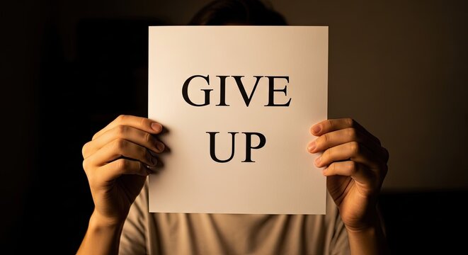 Person holding a sign that reads 'give up'