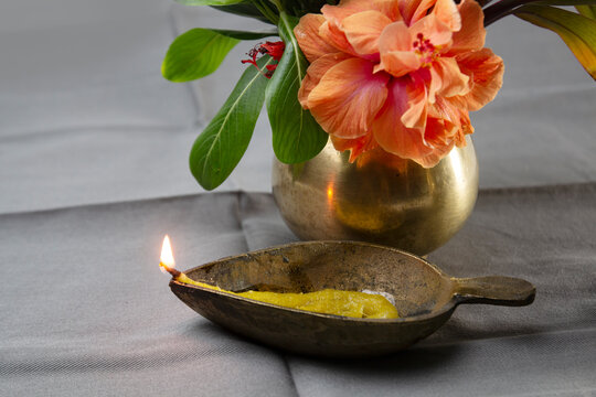 Holy oil lamp flame and Puja ghat with joba or china rose. Brass lamp with mustard oil. Brass pooja pot or vessel.