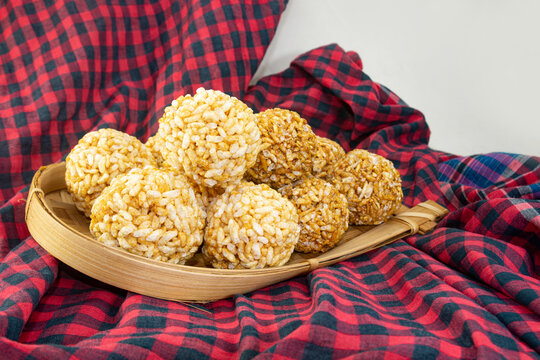 Bengali Traditional Puffed Rice Balls is a sweet made using puffed rice mixed with jaggery, Murmura Laddoo, Churmura Laddoo or Pori Urundai. flattened rice sweet ball or Chirar moa on bamboo tray.