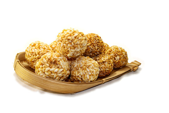 Bengali Traditional Puffed Rice Balls is a sweet made using puffed rice mixed with jaggery, Murmura Laddoo, Churmura Laddoo or Pori Urundai. flattened rice sweet ball or Chirar moa on bamboo tray.