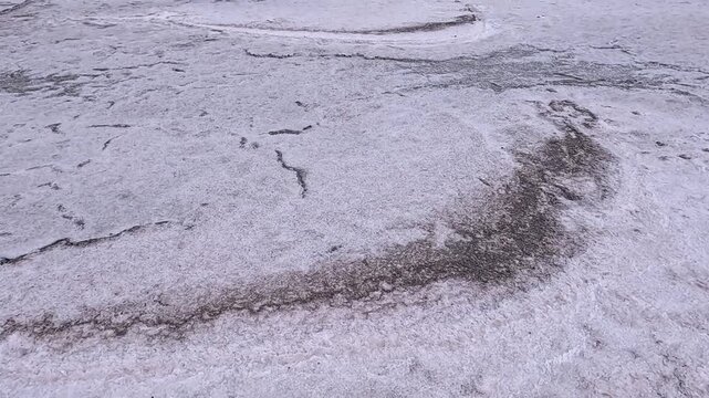 The Kuyalnik Estuary in the Odessa Oblast, Ukraine: black dust deposited on the shoreline covered with white table salt crystals of sodium chloride (NaCl)