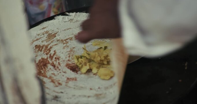 Street style dosa making on an Indian roadside stall, crispy dosa being prepared live with spicy potato chutney filling, authentic South Indian street food experience