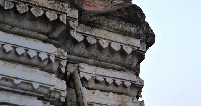 Urban construction is causing damage to an old temple, highlighting heritage destruction and the impact of rapid city development on cultural sites