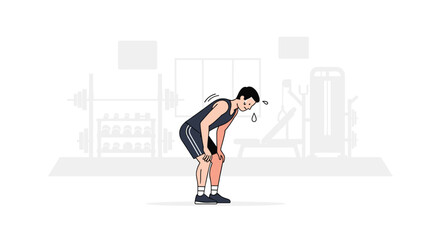 Fototapeta premium A male athlete, bent over and sweating, rests on his knees in a gym with equipment in the background.