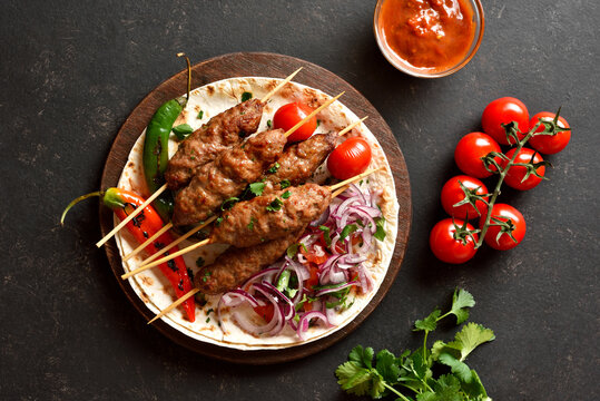 Grilled lula kebab with fresh vegetables on flat bread