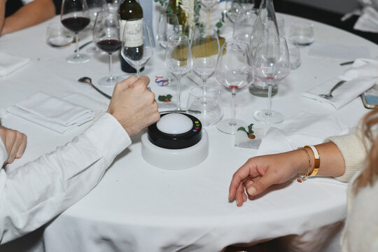 Guests playing table game with buzzer during wedding dinner reception