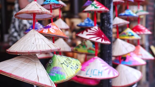 Vietnamese conical hat souvenir hanging decoration closeup. Concept of cultural heritage, travel memory, traditional craft, asian identity, authentic handmade ornament. Selective focus.