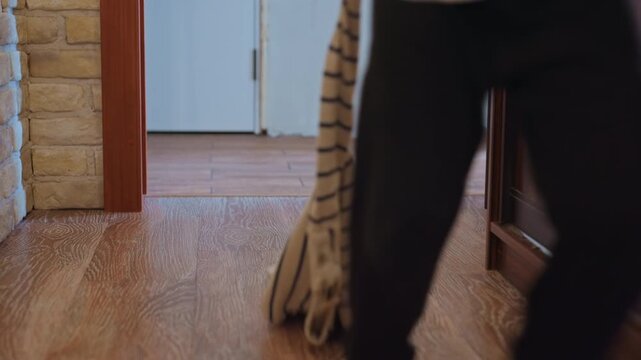 Barefoot son running down hallway, wooden floor and narrow corridor, tiny feet tapping parquet, child dashes past doorway while parent calls, warm domestic light and playful energy