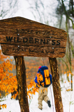 A backpacker passes a trail sign in North Carolina's Middle Prong Wilderness in winter.